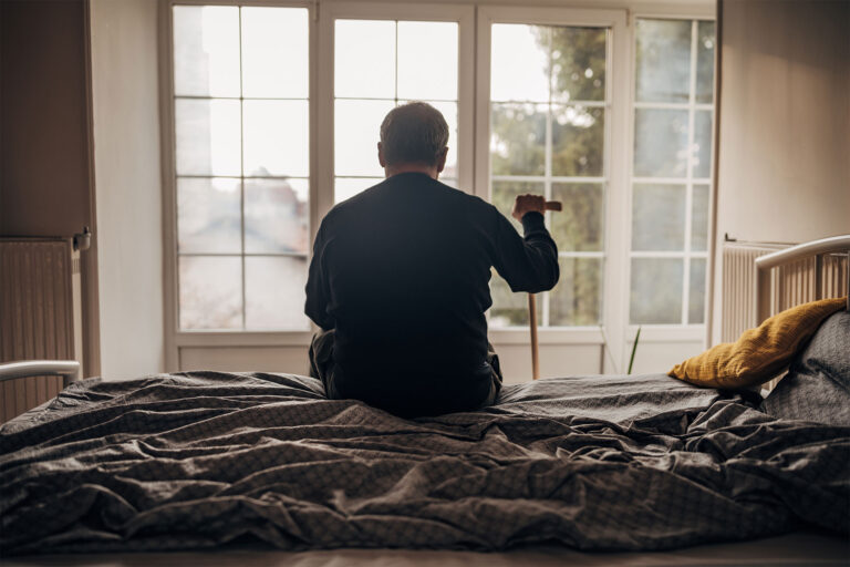 Elderly man looking out window